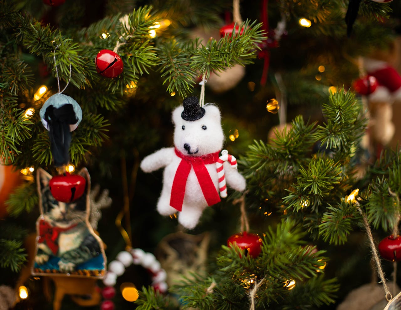 Festive Christmas tree with handmade winter bear ornament and bright lights.