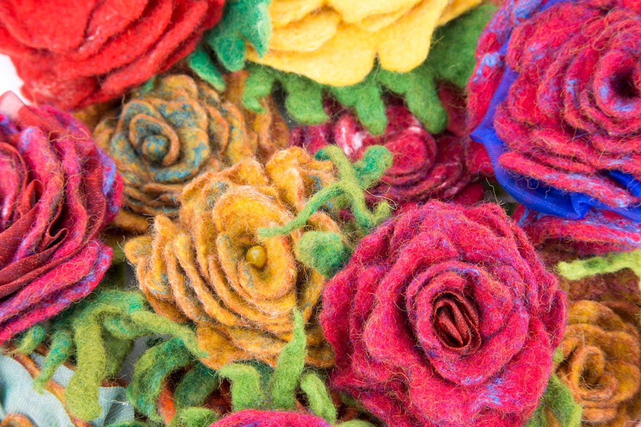 A close-up of vibrant handmade felt roses with rich textures and colors.